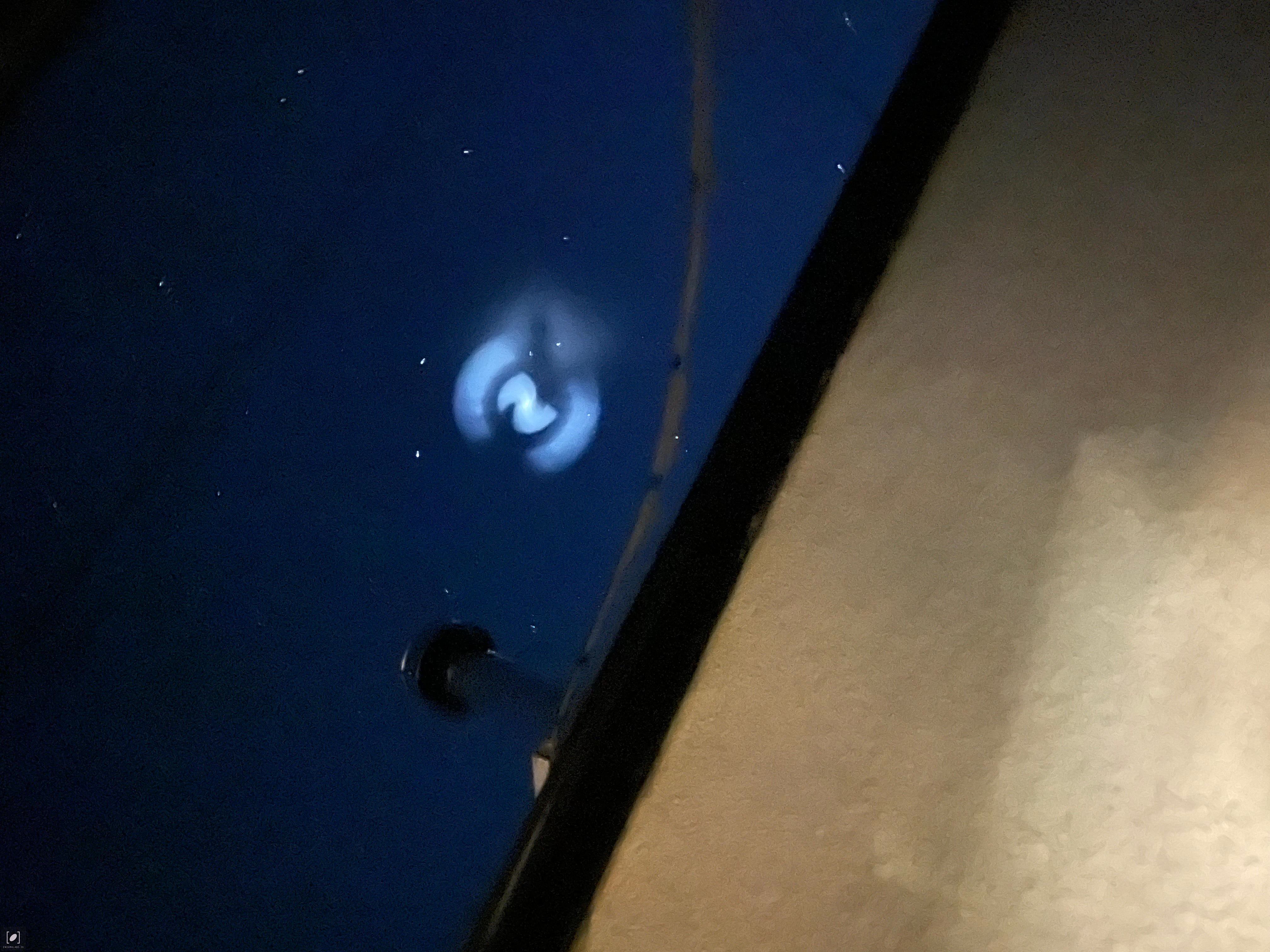 Multi colored light spiral with smaller orbs moving west to east